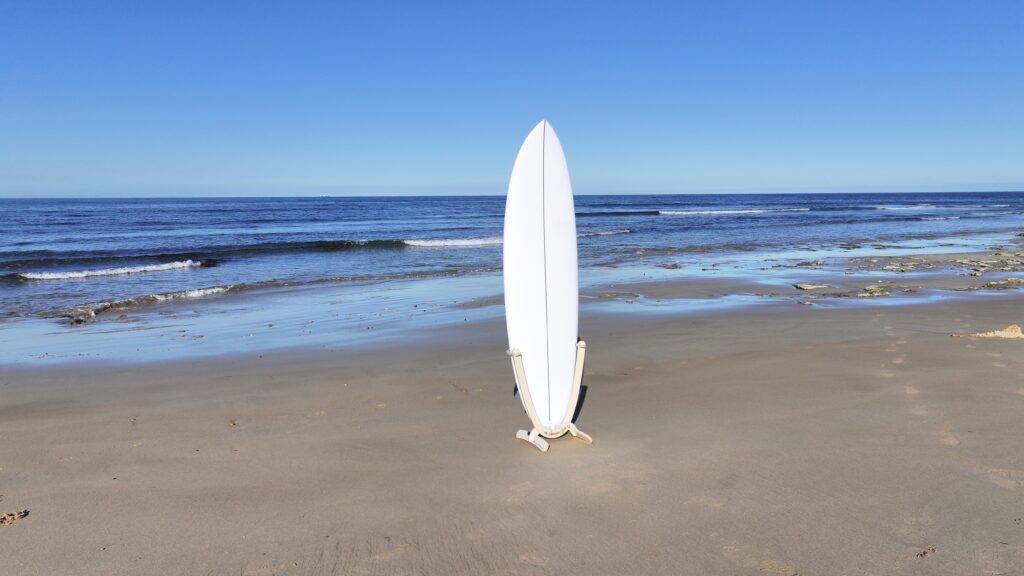 GLYD O Revolute Single Board Rack with surfboard mounted, standing on Point Impossible beach. Ocean in background.
