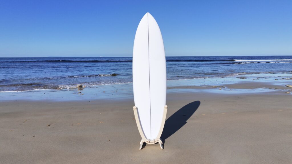 GLYD O Revolute Single Board Rack with surfboard mounted, standing on Point Impossible beach. Ocean in background.