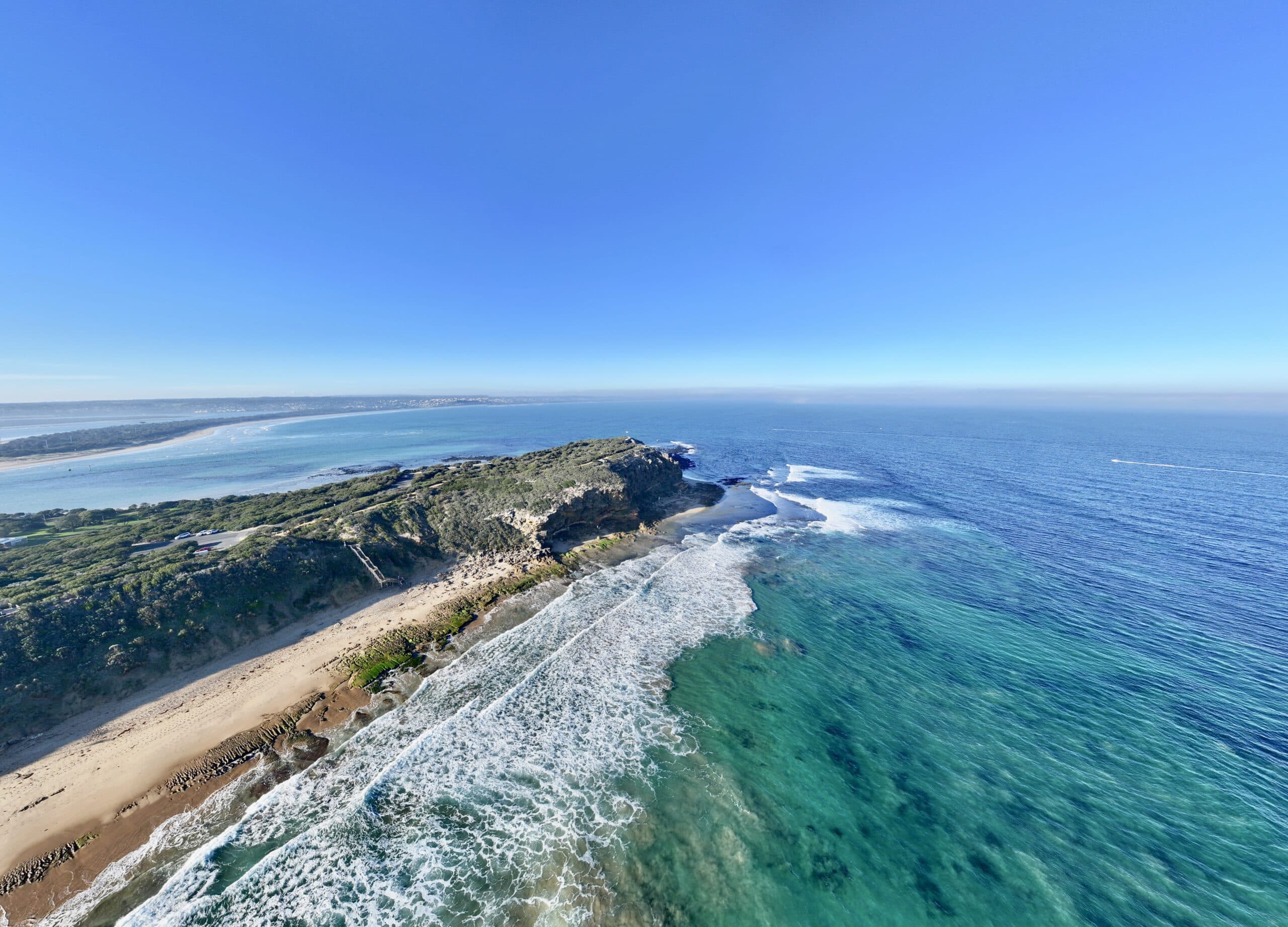 Aerial view of The Bluff Barwon Heads looking east toward Point Lonsdale with jutting headland and Ocean Grove coastline.