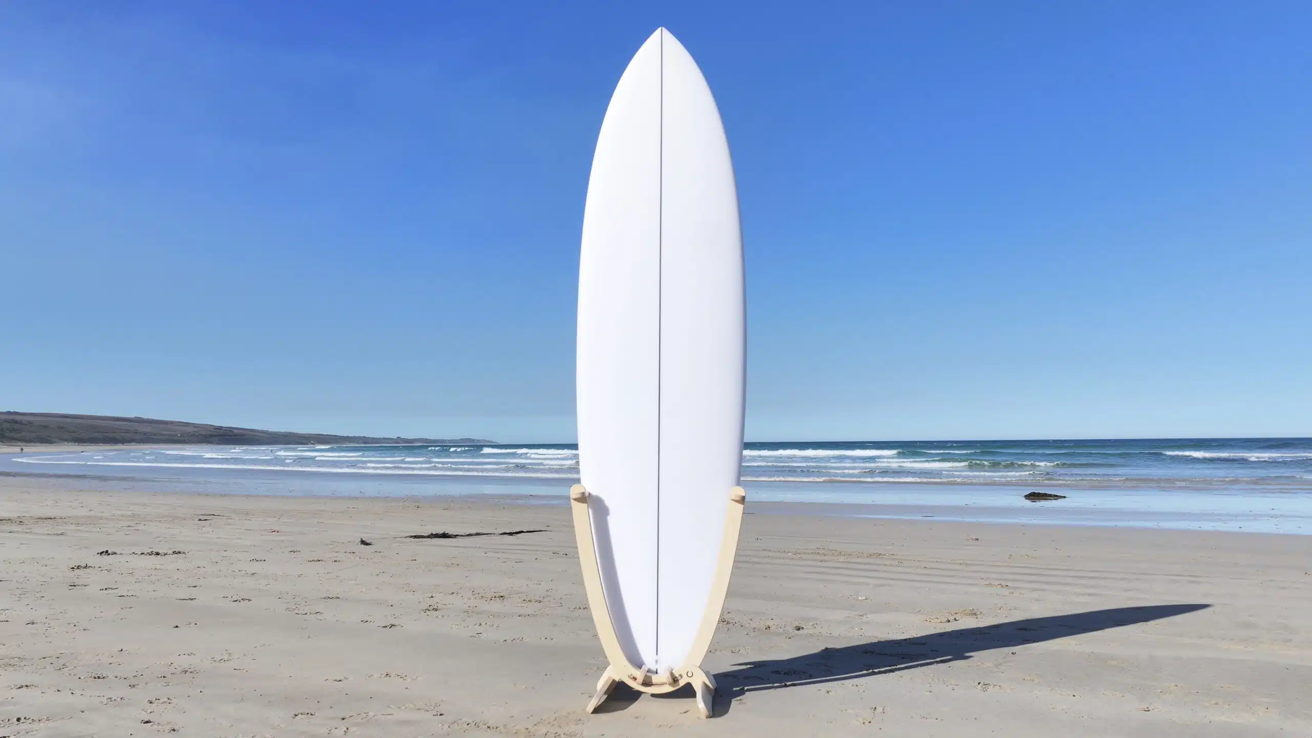 GLYD O Revolute vertical surfboard rack white surfboard Urquharts Bluff beach wooden surfboard display stand.