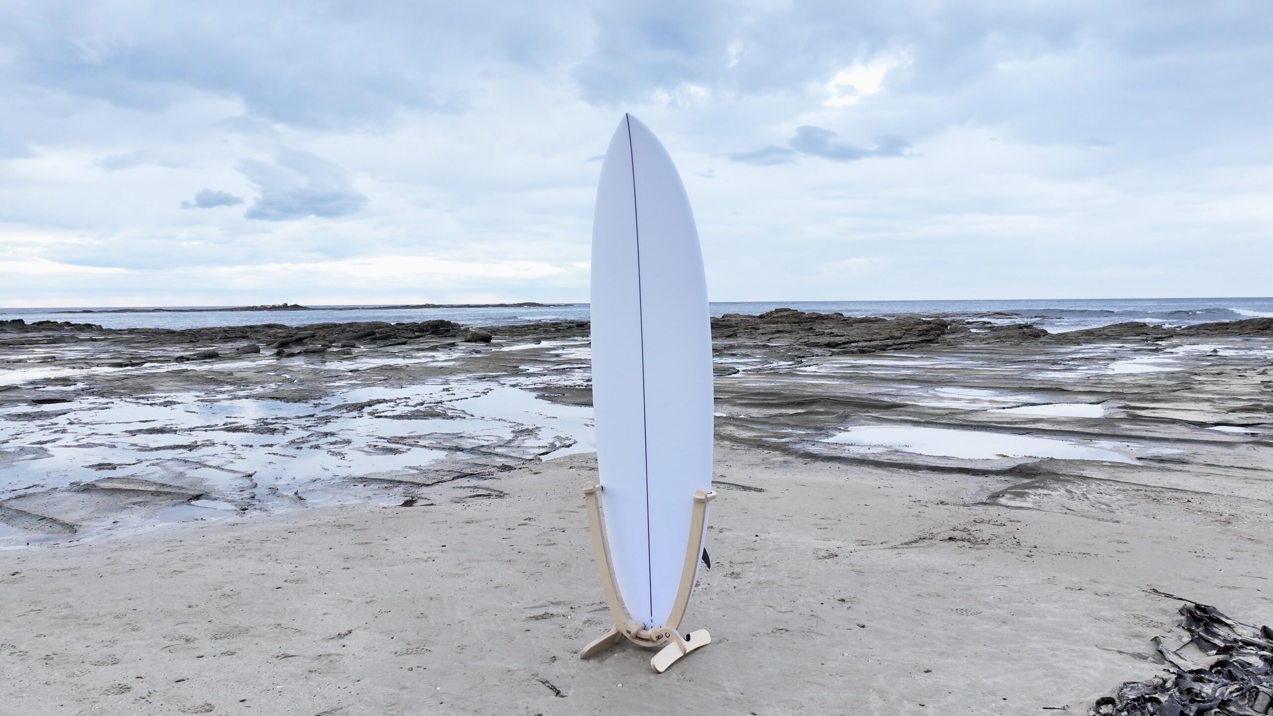 GLYD O Revolute vertical surfboard stand displaying white surfboard on Marengo Point reef looking east.