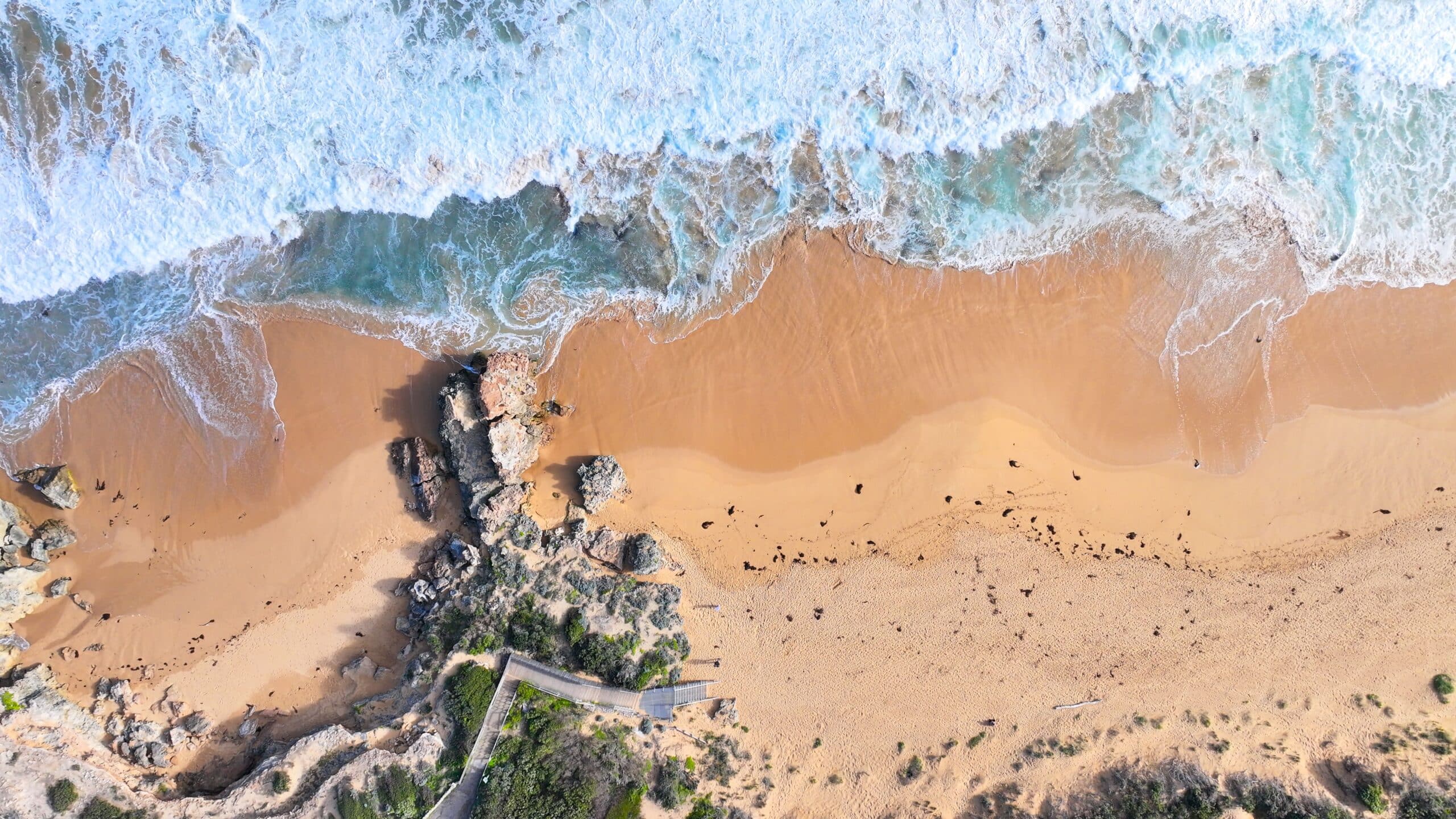 Aerial view of Point Ritchie beach in Warrnambool with GLYD O Revolute Surfboard Display Stand on the sand